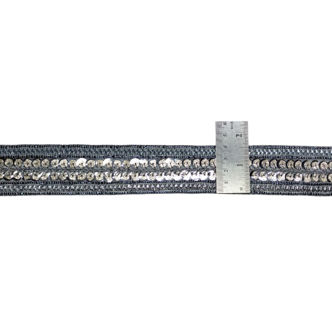 Gray strap with decorative elements and a ruler for scale on a white background